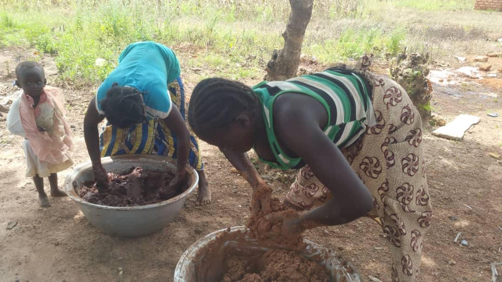 Femmes africaines fabricant du beurre de karité au Burkina Faso. Photo pour le compte de la marque Iwalewa de cheveux afro, crépus, bouclés très secs ne retenant pas l'hydratation. Produits 100% fabriqués en Afrique pour une consommation plus responsable 